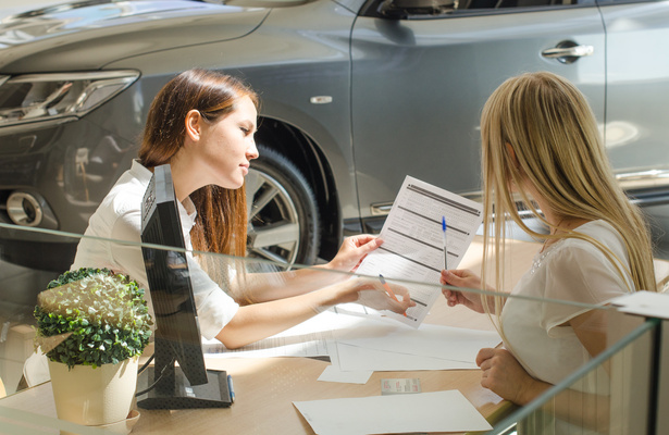 Two women doing paperwork for a small car loan