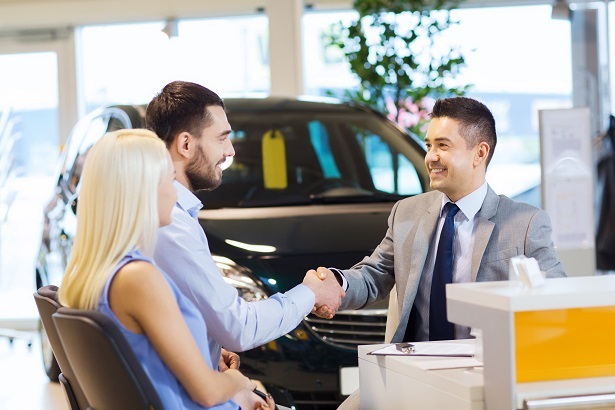 couple getting a car loan at a dealership